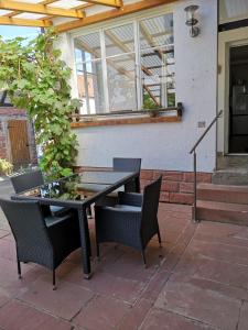 - une table et des chaises noires sur la terrasse dans l'établissement gemütliches Sandsteinhaus, à Buergstadt