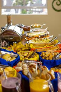 une table recouverte de beaucoup de différents types de nourriture dans l'établissement Pousada Kaliman Premium, à Campos do Jordão