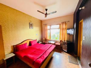 a bedroom with a red bed and a window at Grand view lodge and Restaurant Dharamshala - Partial Prepayment required to confirm booking in Dharamshala