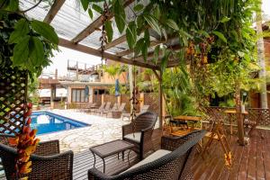 an outdoor patio with chairs and a swimming pool at Pousada Descanso do Rei - Vista Para o Mar & Melhor Localização da Praia do Rosa in Praia do Rosa
