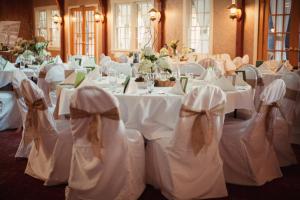 a room full of tables with white clothed chairs at The Lodge at Leathem Smith in Sturgeon Bay