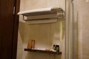 uma casa de banho com um chuveiro e uma toalha numa prateleira em Room 23 Hotel em Akçay