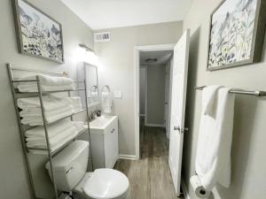 a bathroom with a toilet and a sink and towels at Rad Retreat - Pet Friendly - King Bed - Long Term Stays in Durham