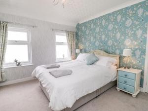 a bedroom with a large bed with a blue wall at 7 Marine Drive in Hartlepool