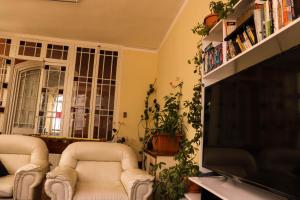 a living room with two chairs and a flat screen tv at Wake Up Hostel in La Paz