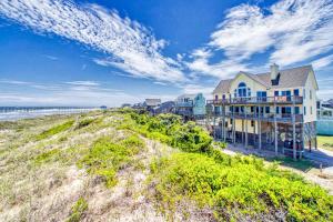 a house on top of a hill next to the ocean at Doc Holiday 126 in Avon
