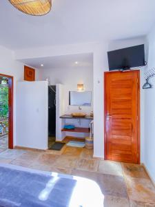 um quarto com uma porta e uma televisão na parede em BEACH VILLA Camurupim em Guajiru