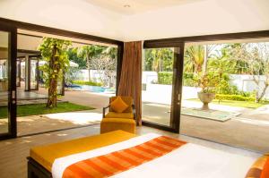 a bedroom with a bed and a view of a pool at Baan Chom Tawan Villa in Lipa Noi