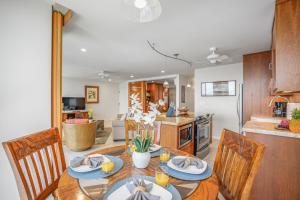 uma cozinha e sala de jantar com mesa e cadeiras em Kuhio Shores 410 em Koloa