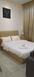 a bedroom with a large bed with white sheets at Cyberjaya cybersqure peace home in Cyberjaya