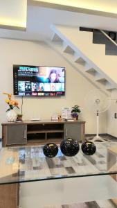 uma sala de estar com uma televisão e um piso de vidro em MAJESTIC 2 BR TOWNHOUSE - near AQUA PLANET & CLark Airport - TRP8 em Malabañas