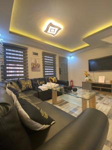 uma sala de estar com um sofá preto e uma televisão em MAJESTIC 2 BR TOWNHOUSE - near AQUA PLANET & CLark Airport - TRP8 em Malabañas