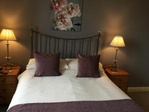 a bedroom with a bed with two lamps on tables at Crown Cottage Farm in Skipton