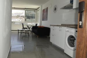 een keuken en een woonkamer met een wasmachine bij Apto. Dulia in Puerto Rico de Gran Canaria