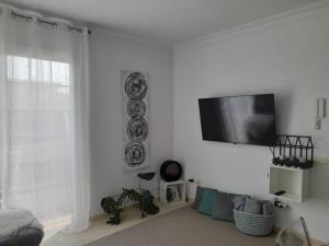 a white room with a flat screen tv on a wall at Arode Apartamento in Los Abrigos