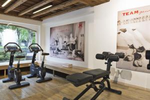 a gym with treadmills and exercise bikes in a room at Neuhaus Zillertal Resort in Mayrhofen
