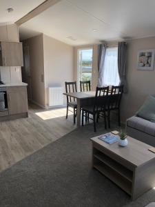 a living room with a table and a couch at Tranquility No 42 Port Haverigg Marina in Millom