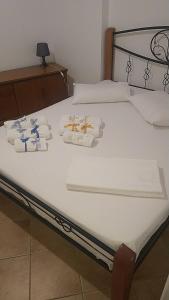 a bed with white sheets and towels on it at Το πετρινο in Agia Marina Mikrolimanou
