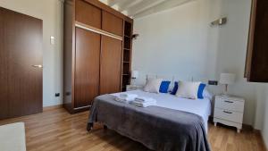 a bedroom with a large white bed with blue pillows at Imeda Apartamentos Escudo del Carmen 19 in Granada