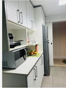 uma cozinha com micro-ondas e algumas frutas no balcão em Apartamento leblon no Rio de Janeiro