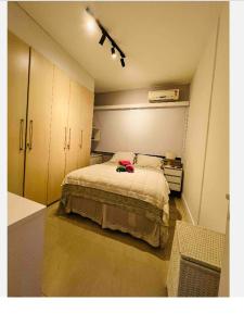 um quarto com uma cama com uma camisa rosa em Apartamento leblon no Rio de Janeiro
