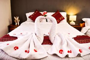 Una cama con dos toallas de cisne. en The Willow B&B, en Urubamba