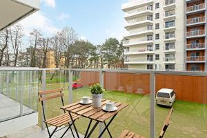 a patio with a table and chairs on a balcony at Seaside Apartments Baltica Tower with Gym, Sauna & Parking in Gdańsk