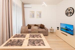 a living room with a couch and a tv at Apartment Odysseus in Tivat