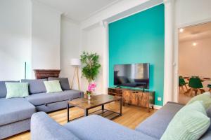 uma sala de estar com 2 sofás e uma televisão de ecrã plano em Appartement Quartier Chatelet Les Halles em Paris
