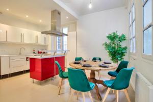 uma cozinha e sala de jantar com uma mesa de madeira e cadeiras em Appartement Quartier Chatelet Les Halles em Paris