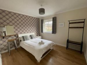 um quarto com uma cama branca e uma janela em The Abercromby Townhouse - Close to Merchant City em Glasgow