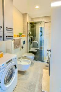 een badkamer met een wasmachine en een toilet bij Apartman Eva, moderan stan u srcu Zagorja in Krapina
