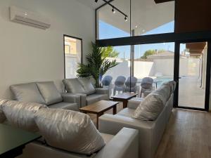 una sala de estar con sofás blancos y una mesa. en Casa rural - bungalows Spa & Relax, en La Felipa