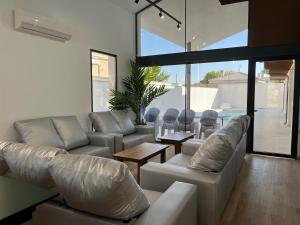 a living room with white couches and a table at Casa rural - bungalows Spa & Relax in La Felipa