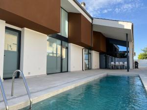 a house with a swimming pool in front of a house at Casa rural - bungalows Spa & Relax in La Felipa