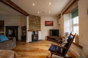a living room with a fireplace and a tv at Coastguard Cottage Cornwall - Sea & Harbour Views in Mevagissey