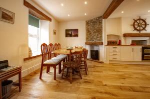 a kitchen and dining room with a table and chairs at Coastguard Cottage Cornwall - Sea & Harbour Views in Mevagissey