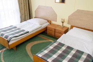 a small bedroom with two beds and a lamp at Pokoje Relax Ostrołęka in Ostrołęka +4 photos