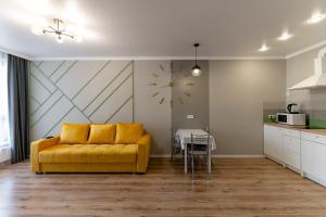 ein Wohnzimmer mit einem gelben Sofa und einem Tisch in der Unterkunft КОРКЕМ НА МАНГИЛИК in Astana