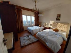 a bedroom with two beds and a window at Omar Apartment in Cairo