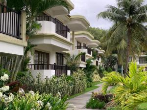 una fila de casas con palmeras y una pasarela en Sonesta Inns Beach Resort - Candolim Beach, en Candolim