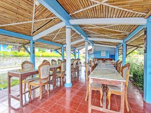 a group of tables and chairs under a roof at Capital O 91644 Loka Hause in Salatiga