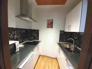 グラナダにあるImeda Apartamentos Escudo del Carmen 19の白いキャビネットと黒板の壁が備わるキッチン
