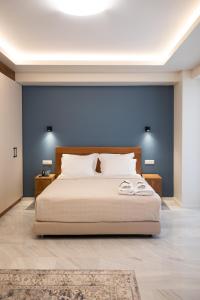um quarto com uma cama grande e uma parede azul em Patras Casale em Patra