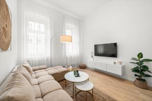 a white living room with a couch and a tv at The BoHo Loft VIE in Vienna