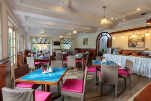 um restaurante com mesas e cadeiras e um bar em Sonesta Inns Beach Resort - Candolim Beach em Candolim