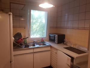 a small kitchen with a sink and a microwave at une chambre privee entre paris et disneyland in Noisy-le-Grand