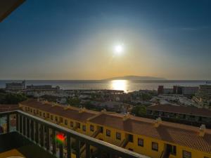 uma vista para o pôr-do-sol a partir da varanda de um edifício em Laguna Park 1 em Adeje
