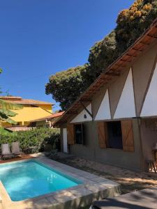 a swimming pool in front of a house at Casa da Rê in Serra do Cipo