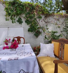 a table and chairs on a patio with flowers on it at Archontiko Stafylopati in Makrinitsa
